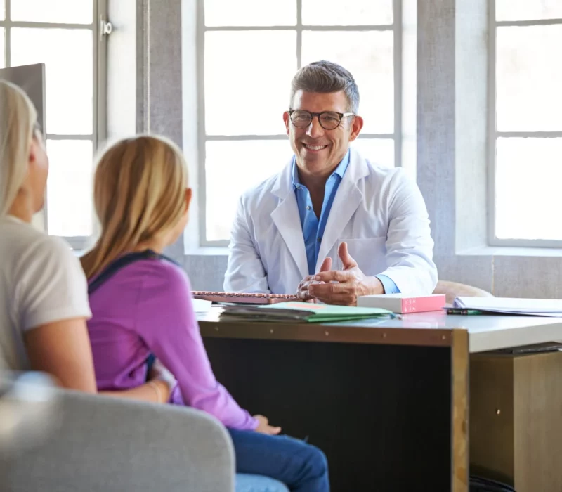 A mother and daughter meeting with a hospital consultant