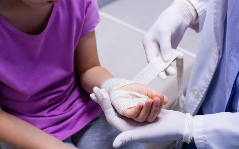 A doctor dressing a patient&rsquo;s hand