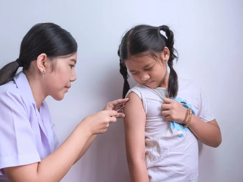 A nurse giving a vaccination to a young girl